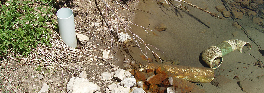 broken piping lies in water next to a wellhead