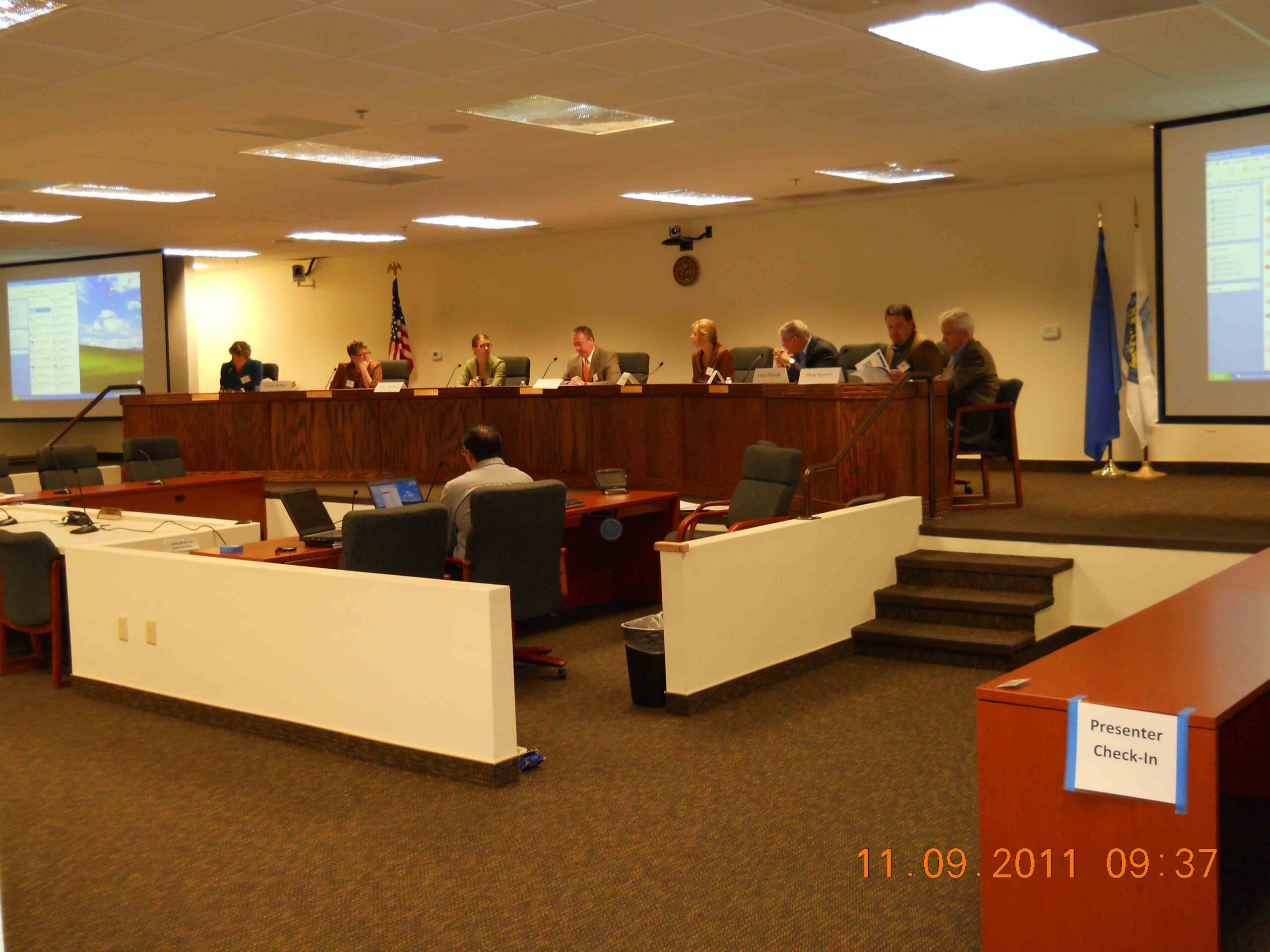 A Board of County Commissioners meeting with board members sitting at the bench in discussion